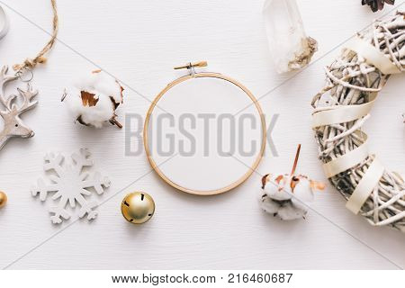 Flat lay top view photo of a mockup with an embroidery hoop and Christmas de. Stylish feminine new year layout composition.