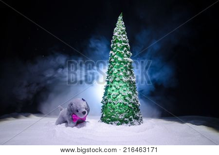 Toy Dog - A Symbol Of The New Year Under The Snow Against The Background Of Fir Branches. Toy's Dog 