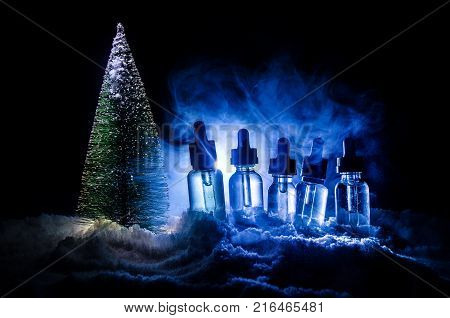 Electronic Cigarette With Vape Liquids And Christmas Decorations On Bokeh Lights Background