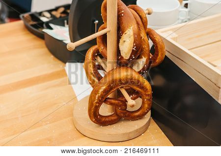 Celebration of the famous German beer festival Oktoberfest. Traditional pretzels called Brezel hang on the stand on the table. Sale of a traditional German snack