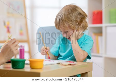 Portrait of kid little boy drawing something for art class