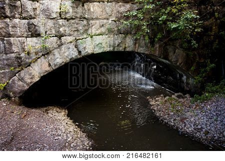 Old Stone Bridge Coverd With Moss And Torrential River.