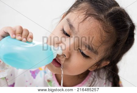 young Asian girl Sick kids cleaning nose with Nasal irrigation