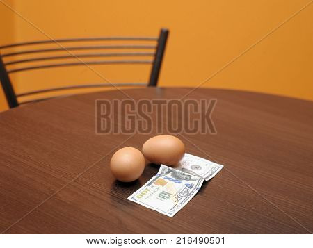 Eggs and a hundred dollar bill laid on the table indoor shot