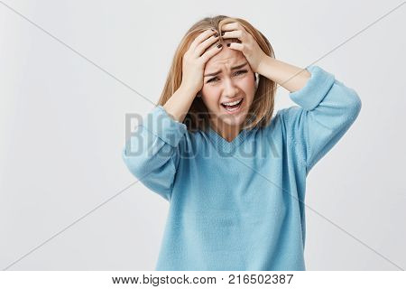 Negative human emotions, reaction and attitude. Frustrated annoyed and angry student girl covering ears with hands, feeling irritated with loud annoying noise, can't concentrate on study