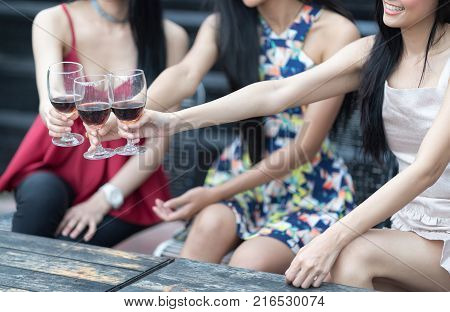 Red wine Christmas party concept. Happy new year coming soon.Closeup of of People hands holding glass celebrating happy drinks with friends.