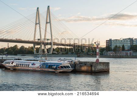 St. Petersburg Russia - September 5 2017: Standing hydrofoil boats at the river wharf with a cable bridge in Sankt-Petersburg Russia