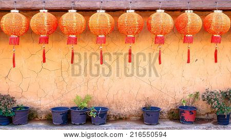 Eight Or 8 Of Red Paper Chinese Lamp With Clay Mud Wall And Old Pot Of Dry Flower.