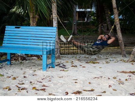 Man Sleeping on a Hammock or a net near on a Beach
