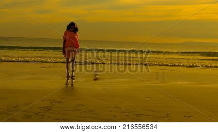 Traveler on a beach with Golden Orange Sunset