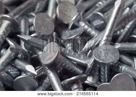 Scattered short chrome metal nails close-up. Chrome
