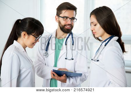 Group of doctors in the clinic discuss the diagnos of the patient