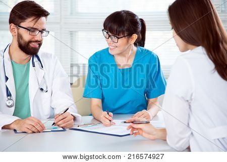 Group of doctors in the clinic discuss the diagnos of the patient