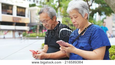 Asian elderly couple use of cellphone together 