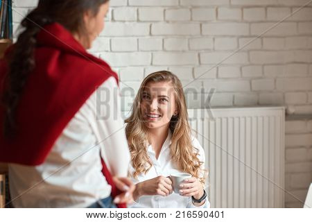 Shot of a beautiful young woman smiling joyfully while talking to her colleague at the office communication lifestyle positivity interaction emotions workers co-workers concept.