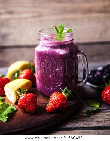Blueberry smoothies on a wooden background with fruits. Vitamins a