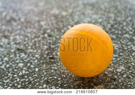 Orange ping pong on the floor.Orange ball place on the table with blue floor between Two Table Tennis paddle or Ping Pong racket, Sport Equipment Concept