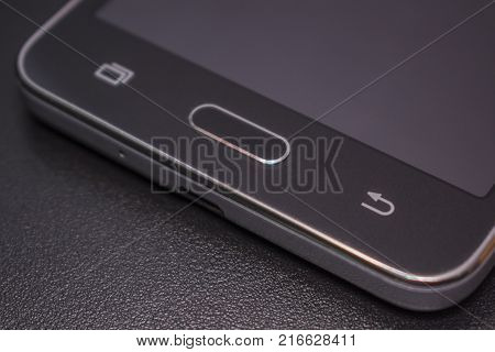 Touch smartphone in black on a black matte background.
