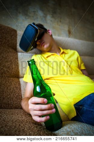 Young Man in VR Glasses with a Beer sleep on the Sofa. Focus on the Bottle