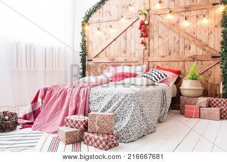 Xmas in morning bedroom. Double bed In christmas Interior on wood wall background.