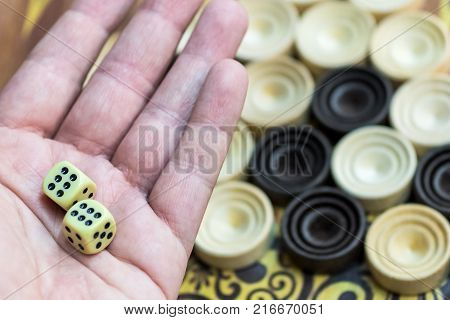 Wooden backgammon. Play a board game. The hand is throwing dice.