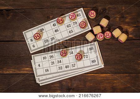 On A Wooden Bingo Table Game, A Cup With A Coffee, A Biscuit And An Orange Slice