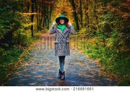 Thoughtful brunette girl walking at park in autumn