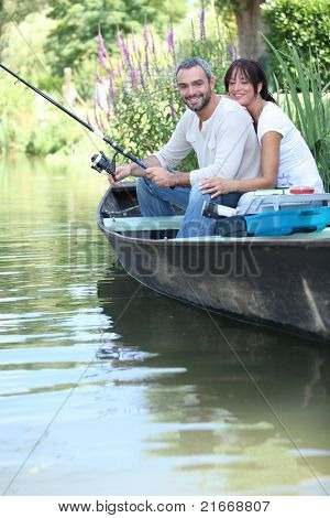 Par fiske i en båt på en flod