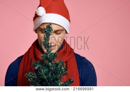 man behind an artificial Christmas tree, free space for copying, new year, holiday.