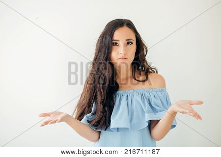 Young woman with a kind of uncomprehending opened his arms to the sides