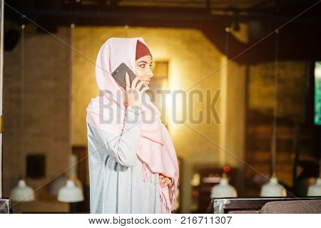 Muslim Woman On Break Using Mobile Phone In cafe