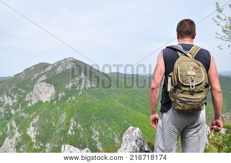 Hiker on top of a mountain enjoy the beautiful view of nature, and mountain on the other side of the canyon. View on mountain Kablar, Serbia