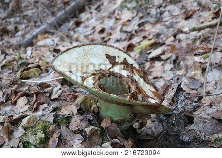 old rusty crumpled plafond for electric street lighting of the Soviet era thrown in the woods