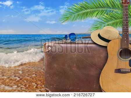 Concept of summer traveling with old suitcase and guitar