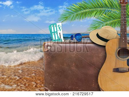 Concept of summer traveling with old suitcase and guitar