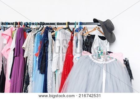 Many ladies evening gown long dresses on hanger in the dress rent shop for photo session. Dresses rental concept. Selective focus. Ball gown rental concept