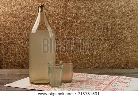 Ukrainian national drink. The big bottle of moonshine. Old bottle and glass with russian vodka.