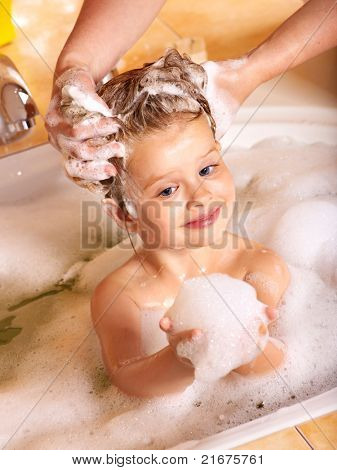 Bambino lavare i capelli nel bagno di bolle.