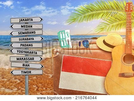 Concept of summer traveling with old suitcase and Indonesia town sign