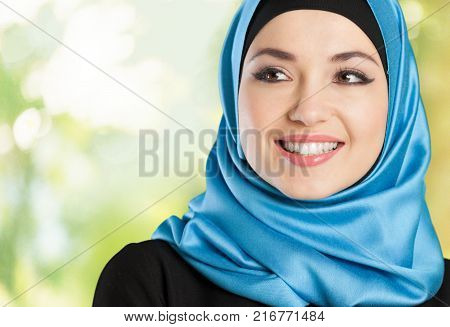 Young woman muslim make up blue background close-up