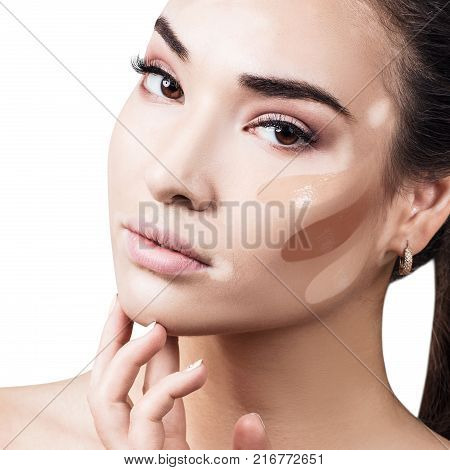 Young woman with vitiligo and soft skin and foundation stripes on face.