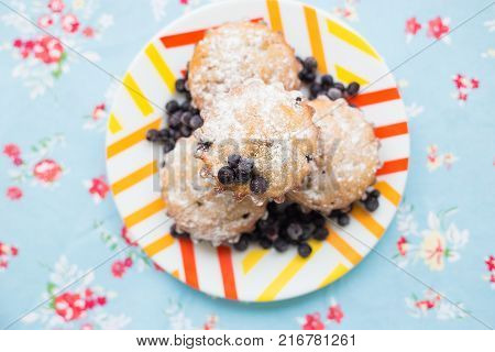 Blueberry muffins on plate and bright floral cloth