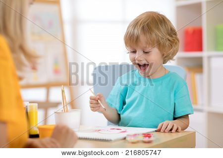Portrait of kid little boy drawing something for art class