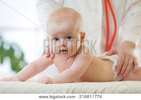 Doctor exams baby infant with stethoscope in the hospital