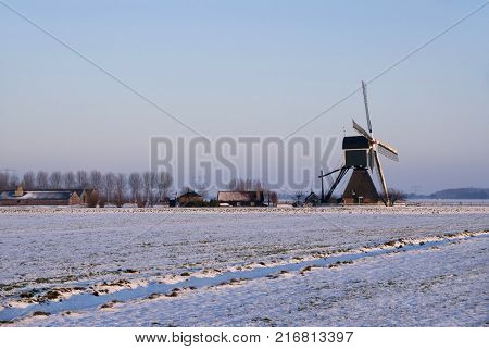 Windmill the Wingerdse Molen in a snow covered landscape near the Dutch village Bleskensgraaf