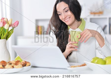 Beautiful  young   woman  using  laptop  at table