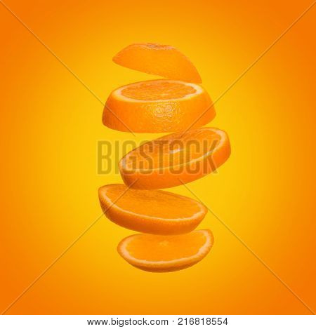 Creative concept with flying orange. Sliced orange on yellow background. Levity fruit floating in the air