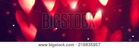 Valentine's Day Background. Holiday Blinking Abstract Valentine Background with Glowing Hearts. Love concept. Wide angle format banner