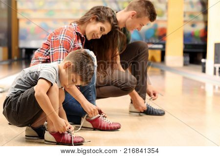 Family changing their shoes in bowling club