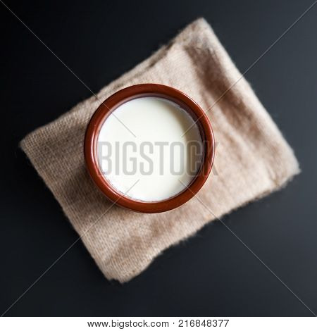 Sour cream or natural Cottage cheese curd in traditional ceramic bowl on dark background. Traditional Cuajada yogurt cream